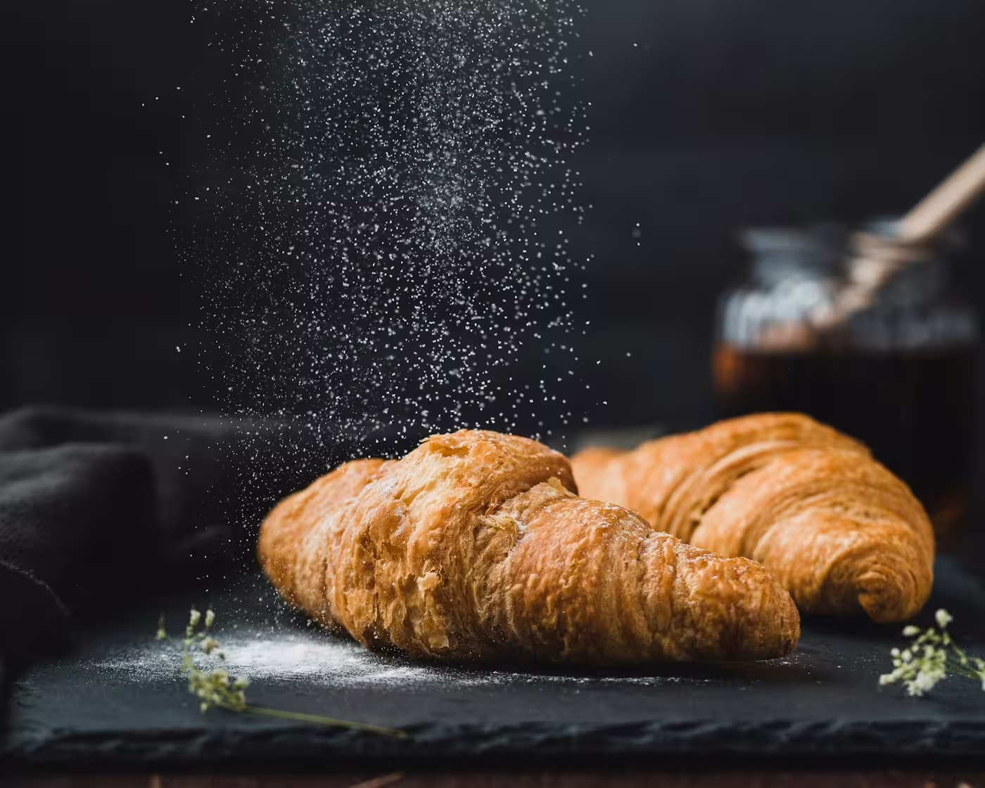 Croissants saupoudrés de sucre glace sur une ardoise